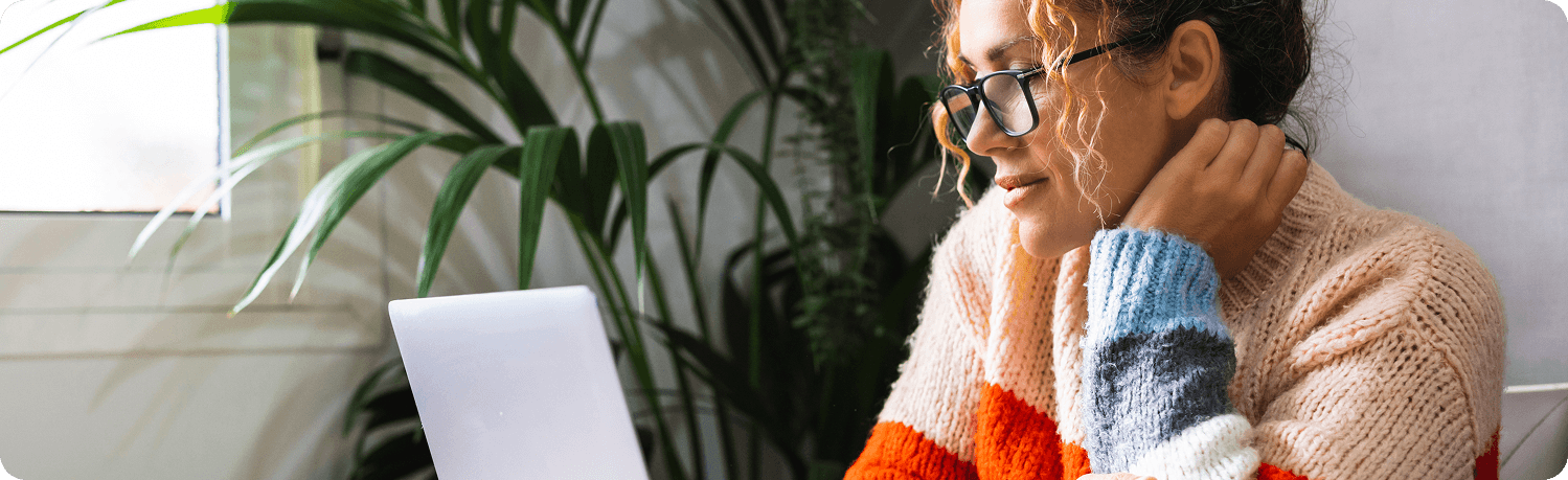Women in colorful sweater using laptop, similar to hero